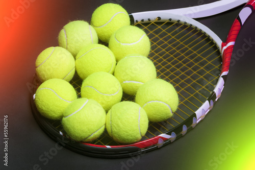 Plenty of tennis Balls on Tennis Racquet Strings against Black b