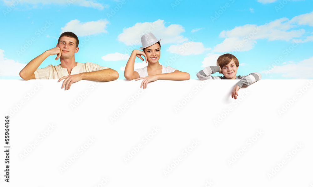 Happy young family with blank banner Happy young family with blank banner