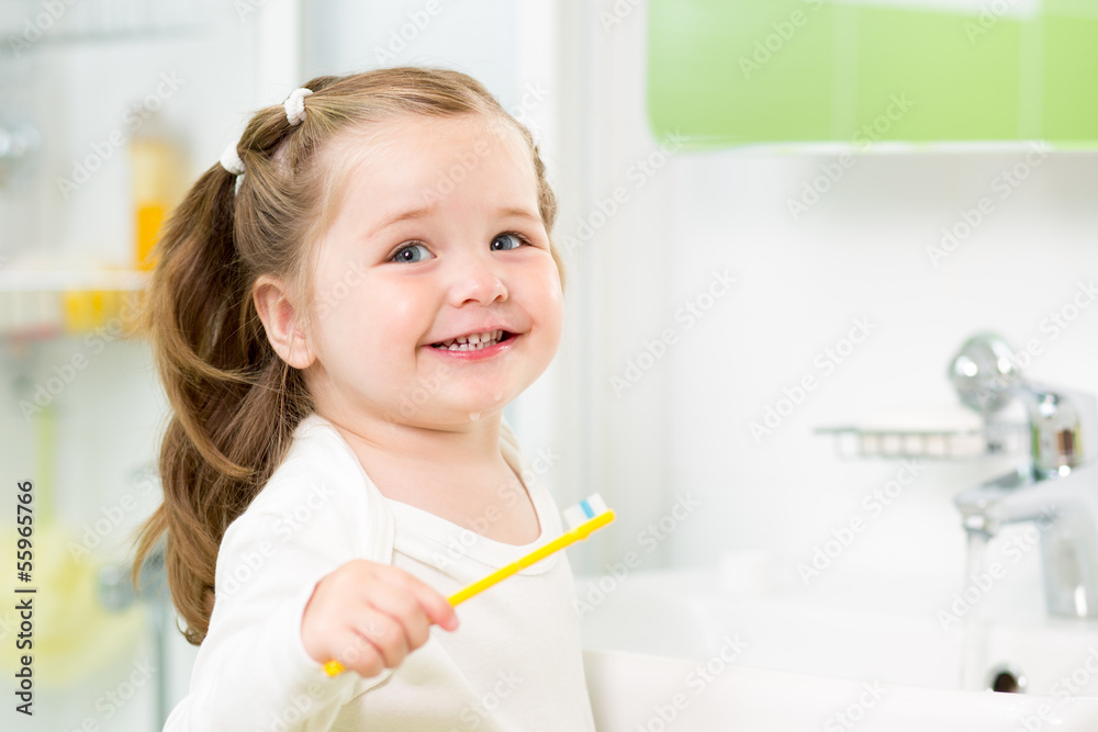 Smiling child girl brushing teeth in bathroom Smiling child girl brushing teeth in bathroom