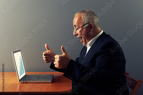 man looking at graph and showing thumbs up