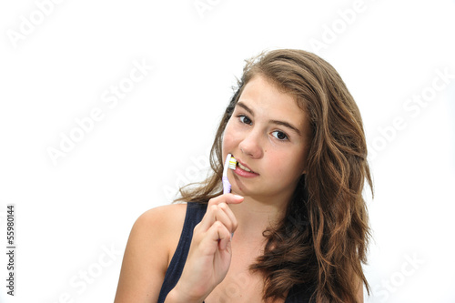 pretty smiling teen brushing her teeth isolated on white 