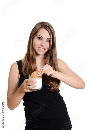 teen girl dunking oatmeal cookie in milk