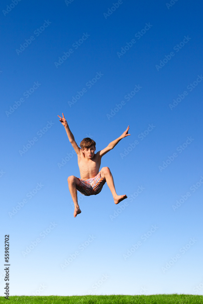 Junge macht einen Sprung auf der Wiese Junge macht einen Sprung auf der Wiese