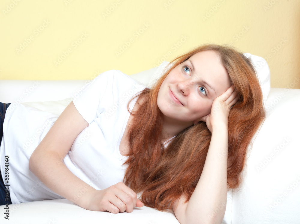 Woman with red hair lying on the sofa Woman with red hair lying on the sofa