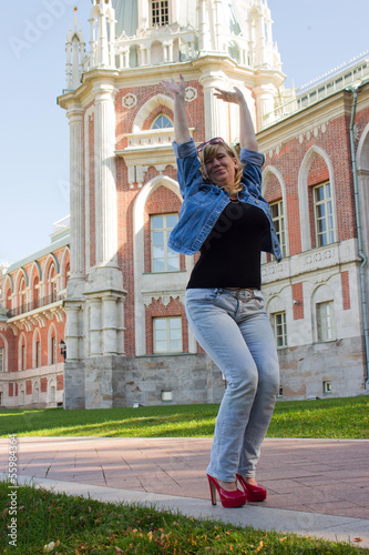 A woman in a blue jacket walking near the Tsaritsyno palace in t