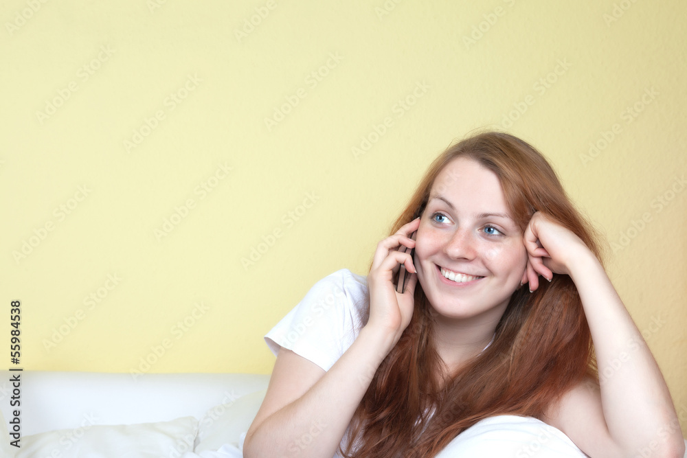 Smiling woman on the couch talking at the phone