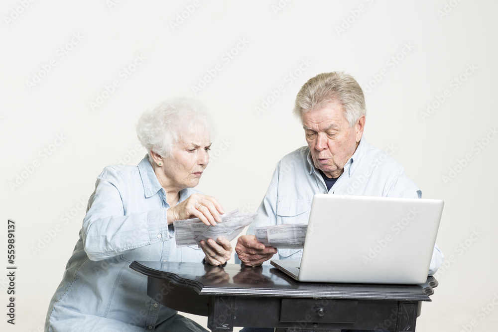 Senior couple is looking at the bills concerned Senior couple is looking at the bills concerned