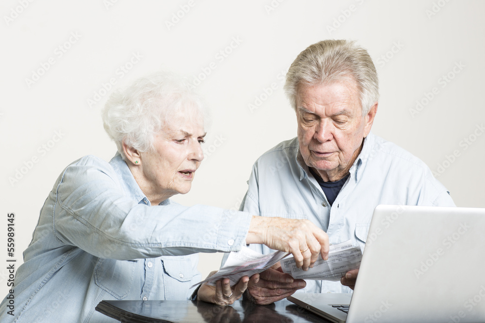 Senior couple is looking at the bills concerned Senior couple is looking at the bills concerned