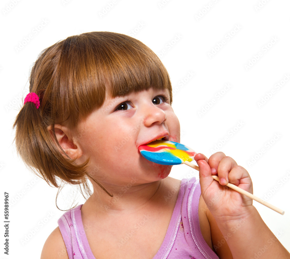 Cute little girl eating a colored lollipop Cute little girl eating a colored lollipop