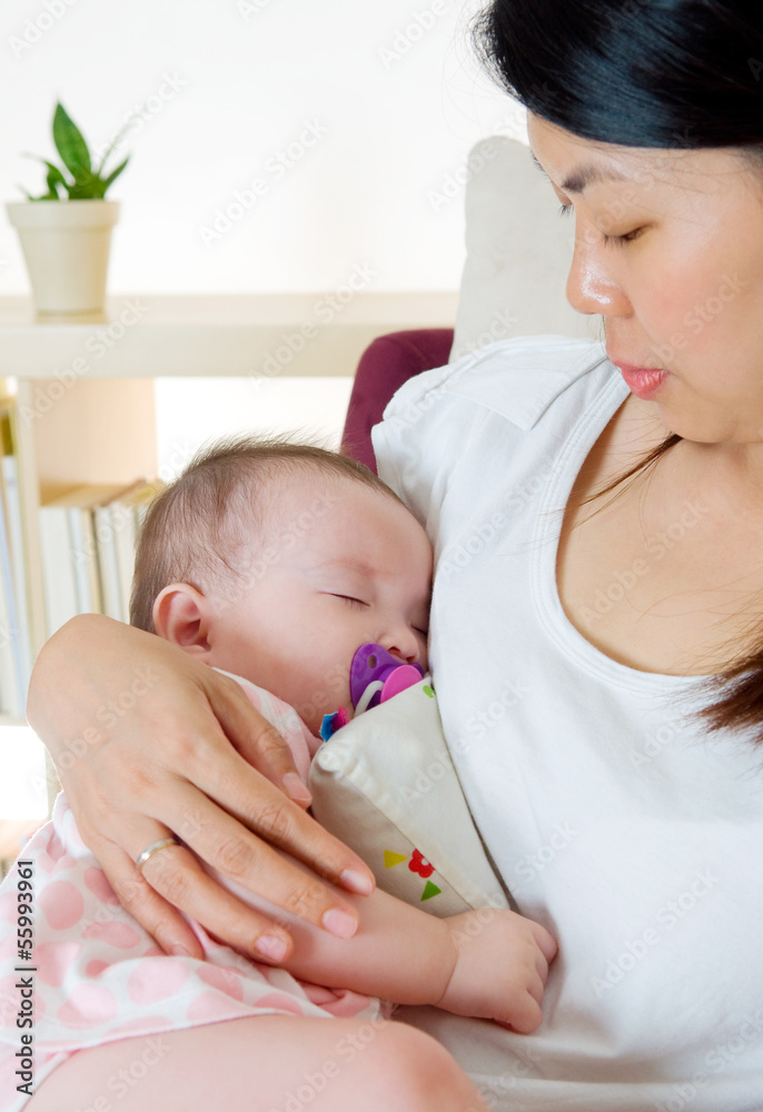 Asian mother holding her sleeping baby Asian mother holding her sleeping baby