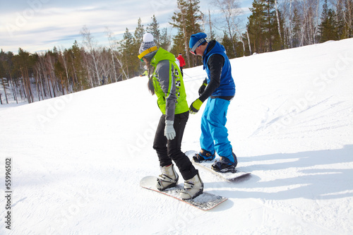 Young couple snowboarders in a ski resort