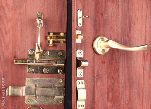 Metal bolts, latches and hooks in wooden open door close-up