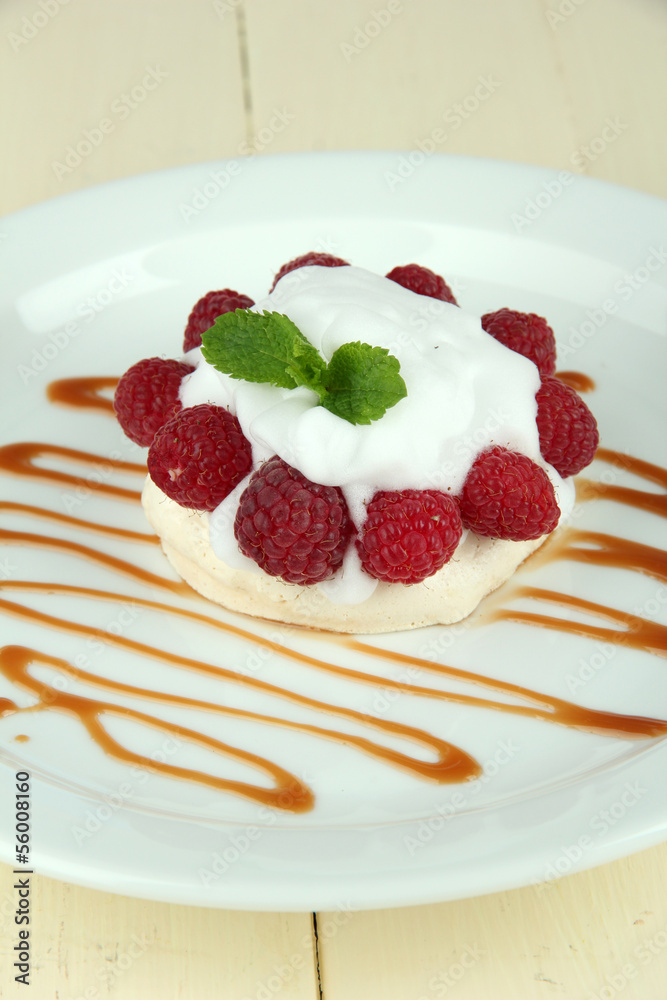 Tasty meringue cake with berries on wooden table Tasty meringue cake with berries on wooden table