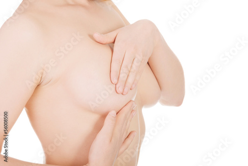 Young woman examining her breast for signs of breast cancer