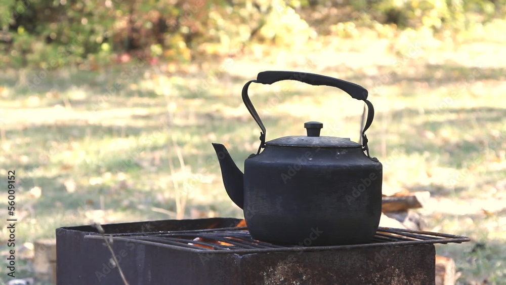 Black old smoked teapot on the campfire Black old smoked teapot on the campfire