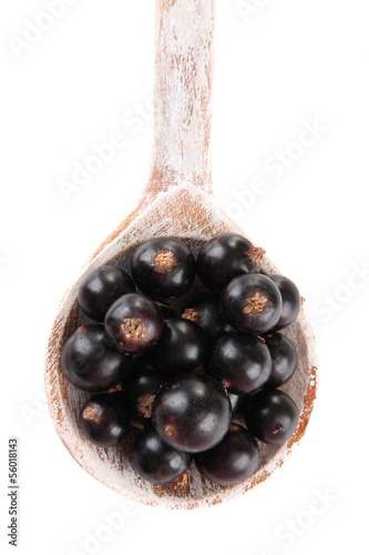 Black currant in wooden spoon isolated on white