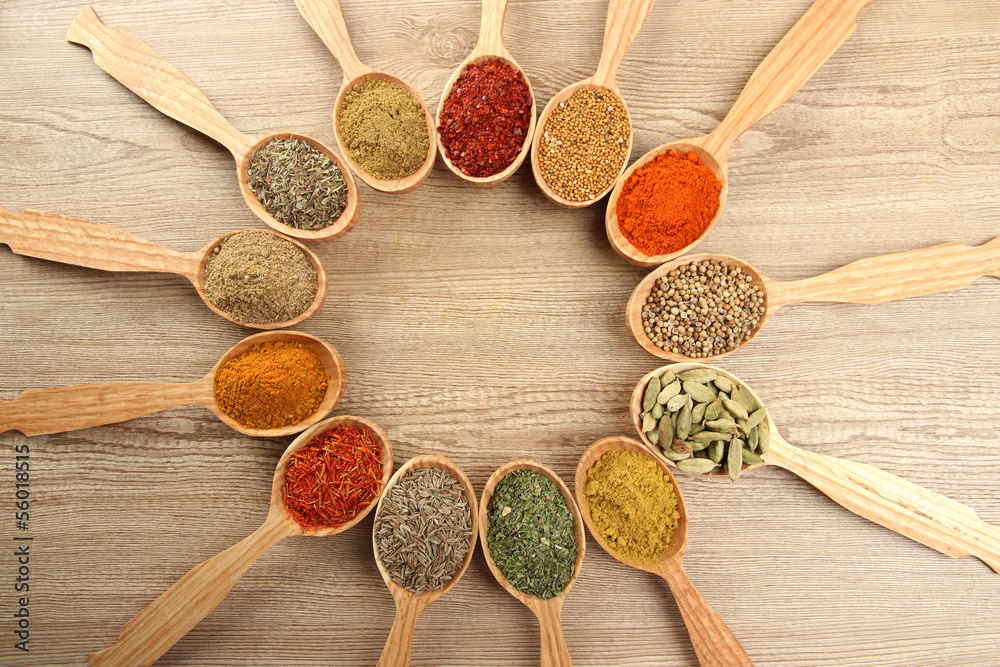 Assortment of spices in wooden spoons on wooden background Assortment of spices in wooden spoons on wooden background