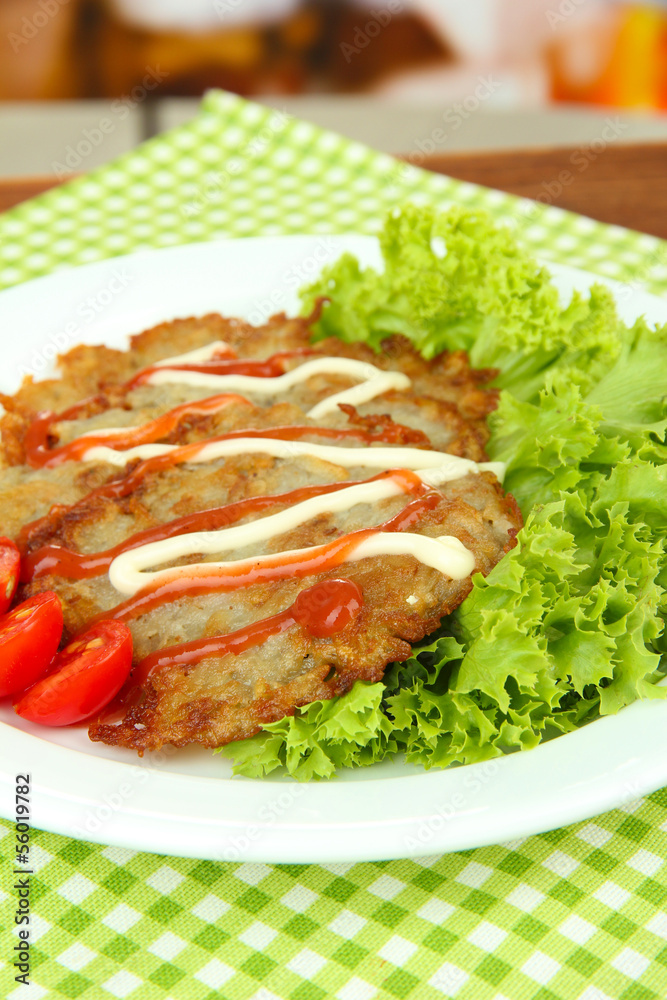 Potato pancakes on plate, on bright background