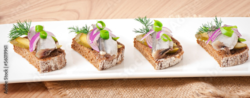 Sandwiches of rye bread with herring, onions and herbs.