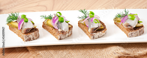 Sandwiches of rye bread with herring, onions and herbs.