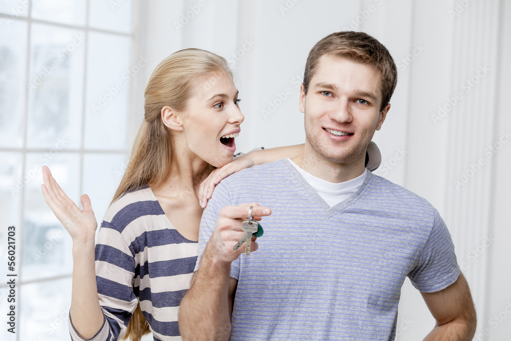 man holding keys and wife standing together man holding keys and wife standing together