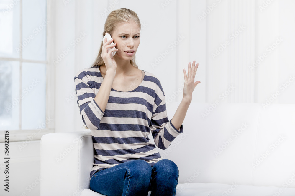 young beautiful blond woman sitting on the couch young beautiful blond woman sitting on the couch