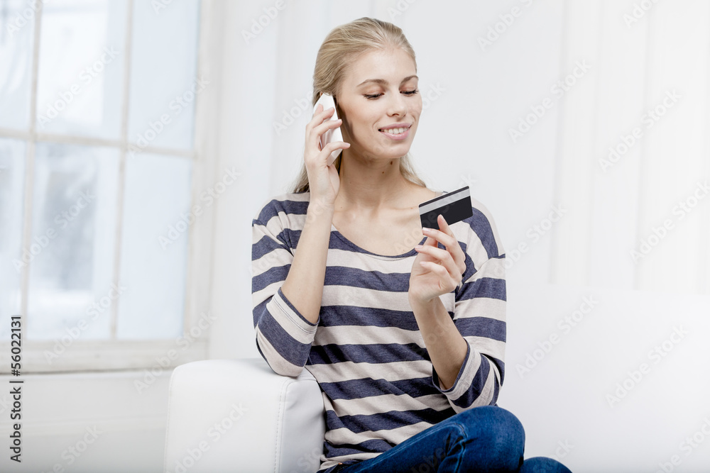 woman sitting on the couch and holding credit card woman sitting on the couch and holding credit card