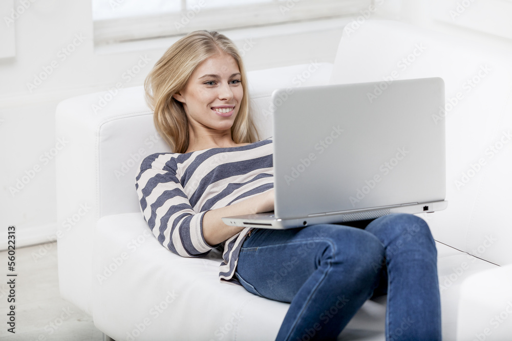 woman laying on the couch with laptop woman laying on the couch with laptop