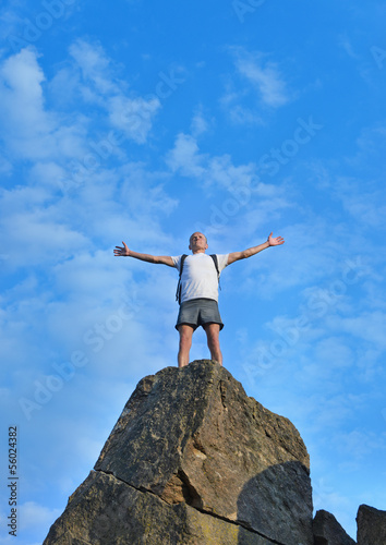 Man celebrating reaching the top of a mountain