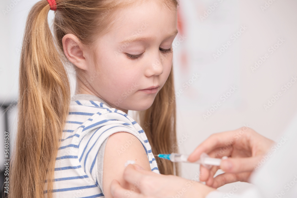 Injection. Close-up of doctor doing injection to a little girl Injection. Close-up of doctor doing injection to a little girl