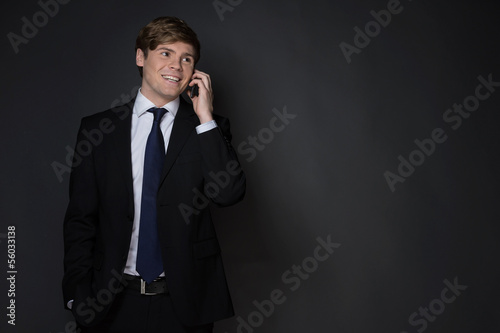 Businessman on the phone. Cheerful young man in formalwear talki photo