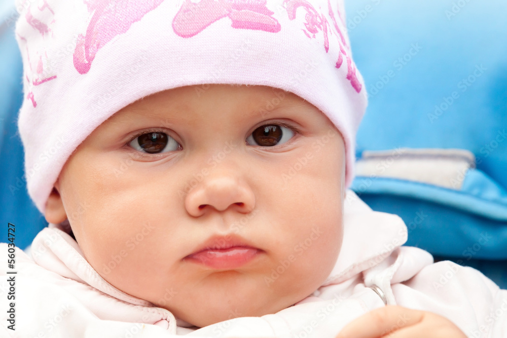 Brown eyed baby girl in pink hat, outdoor closeup portrait Brown eyed baby girl in pink hat, outdoor closeup portrait