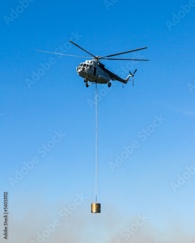 Helicopter in action carrying the water bucket.