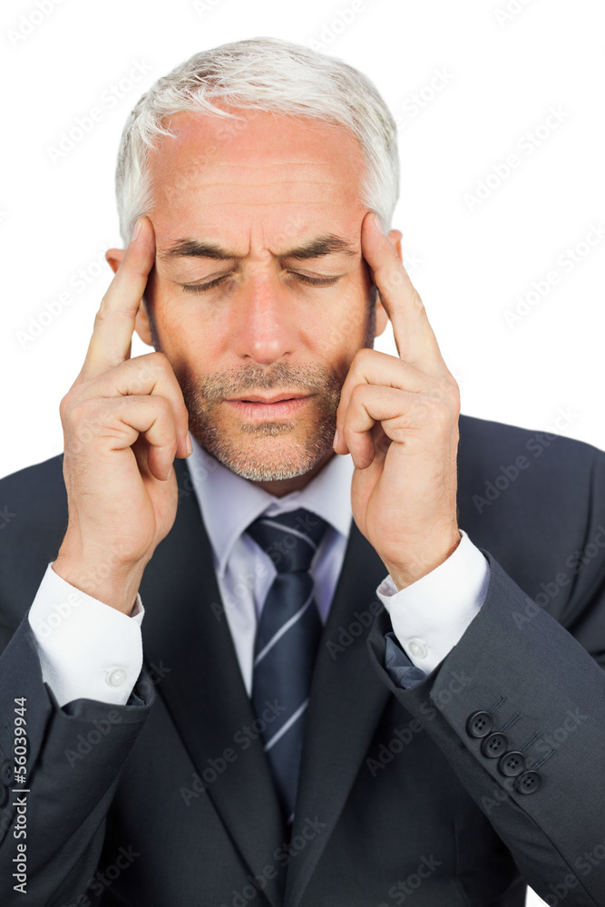 Focused businessman holding his temples Focused businessman holding his temples