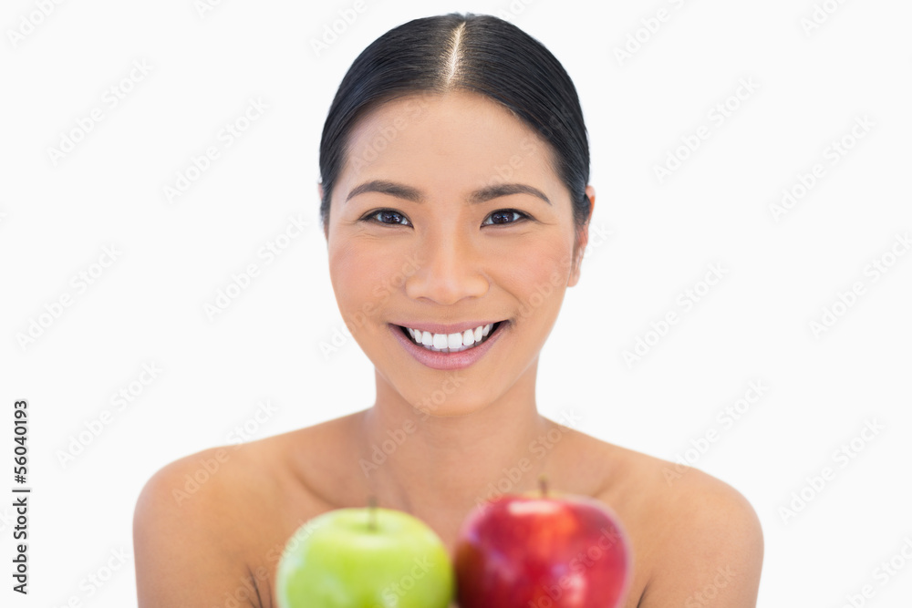 Smiling brunette holding red and green apples Smiling brunette holding red and green apples