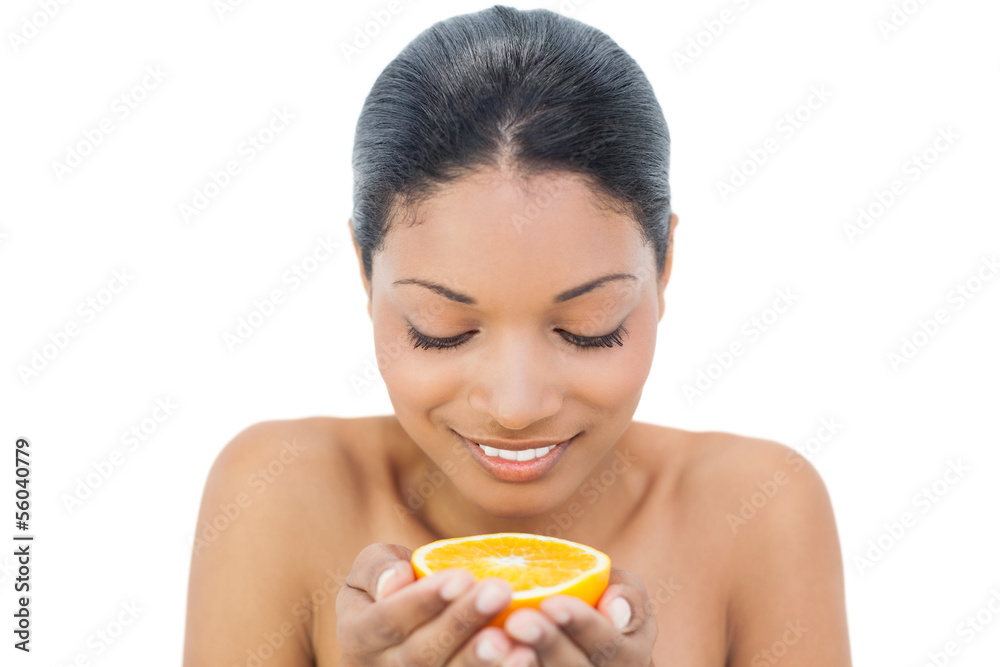 Cheerful black haired model holding orange slice Cheerful black haired model holding orange slice