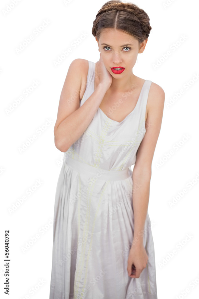 Embarrassed model in white dress posing hand on the neck