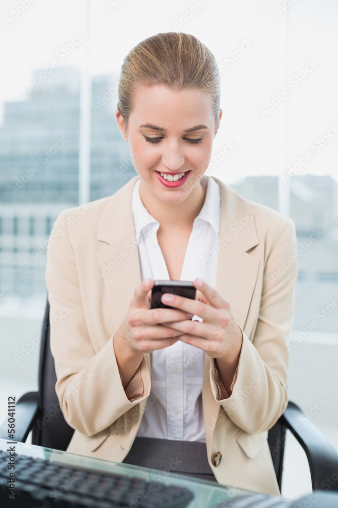 Smiling attractive businesswoman text messaging Smiling attractive businesswoman text messaging