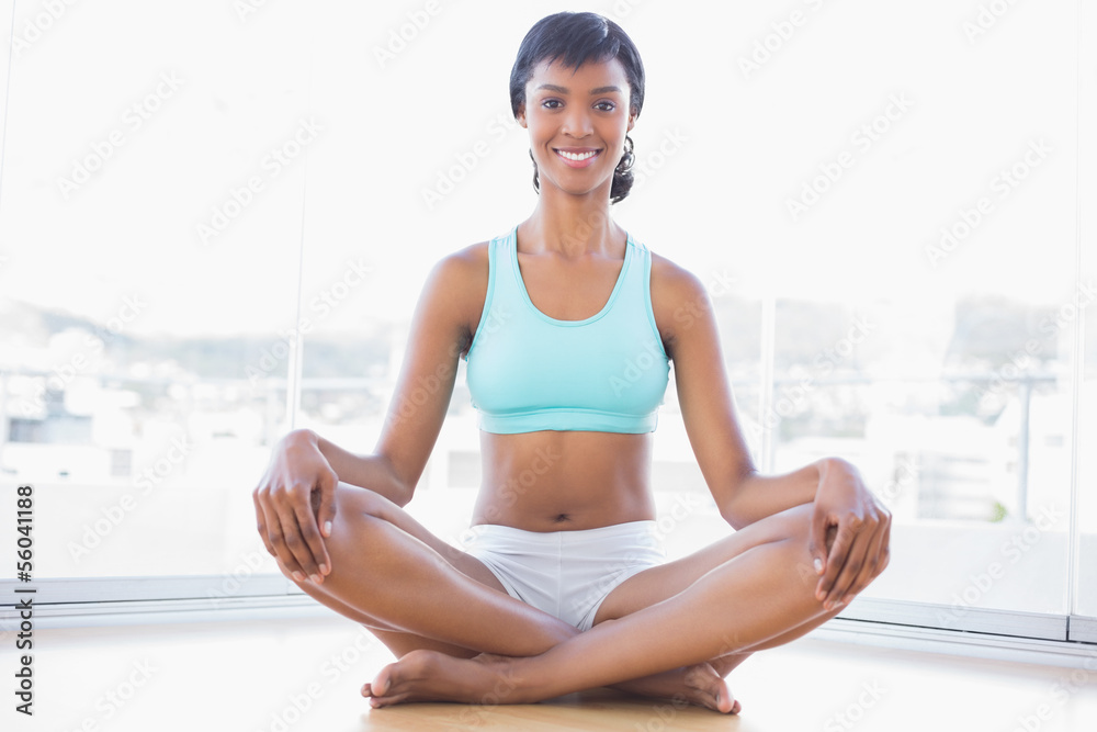 Smiling black haired woman doing yoga