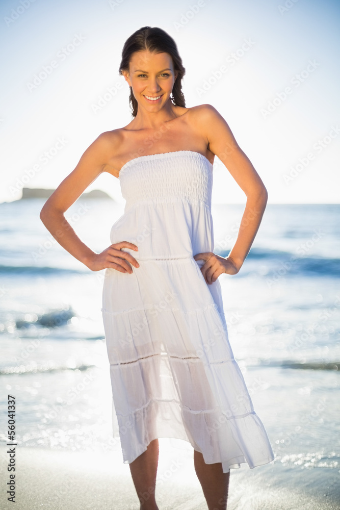 Fototapeta premium Smiling brunette in white summer dress posing