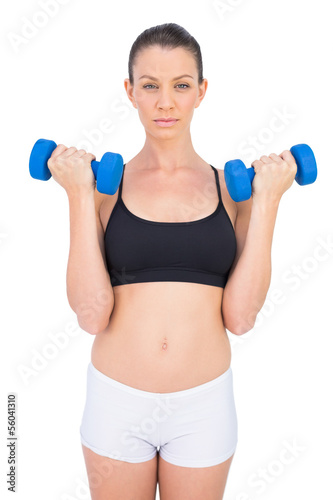 Focused sporty brunette working out with dumbbells