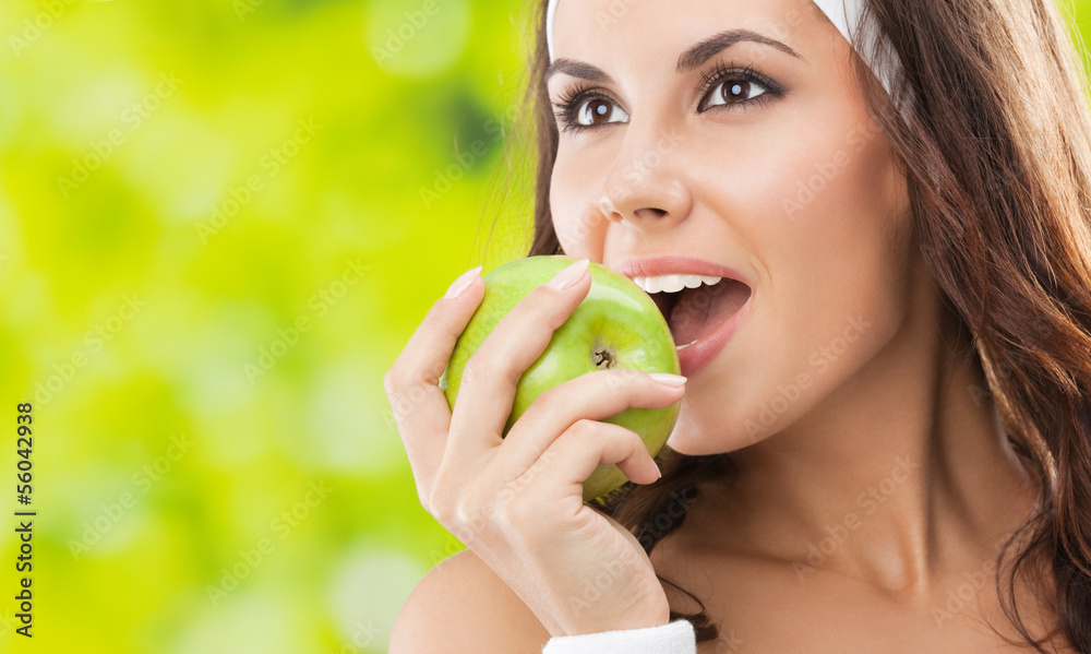 Woman in fitness wear with apple, outdoors Woman in fitness wear with apple, outdoors