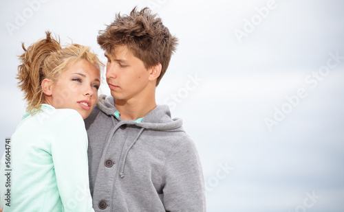 Couple embracing and having fun wearing warm clothes outside on