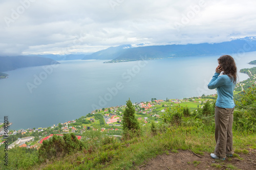 Woman talking on mobile phone at the edge of cliff