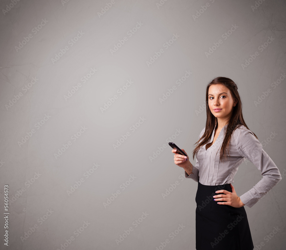 young lady standing and holding a phone with copy space young lady standing and holding a phone with copy space