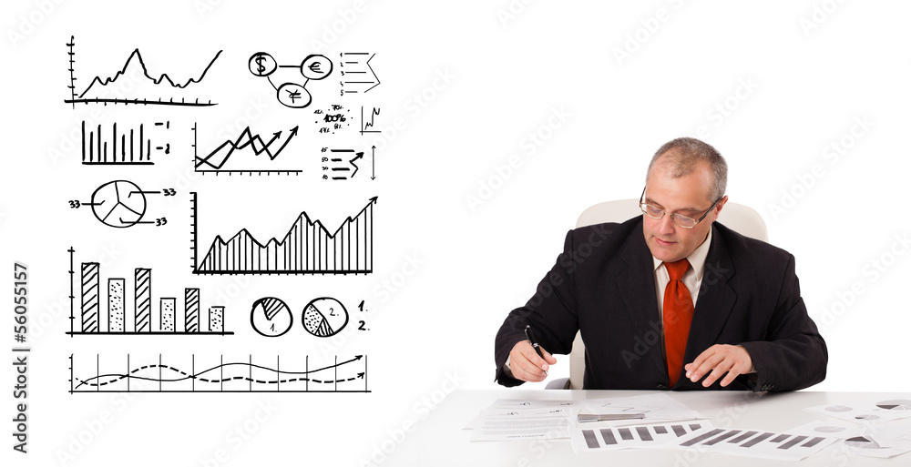 businessman sitting at desk with statistics and graphs businessman sitting at desk with statistics and graphs