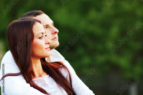 young romantic couple looking at copyspace outdoors