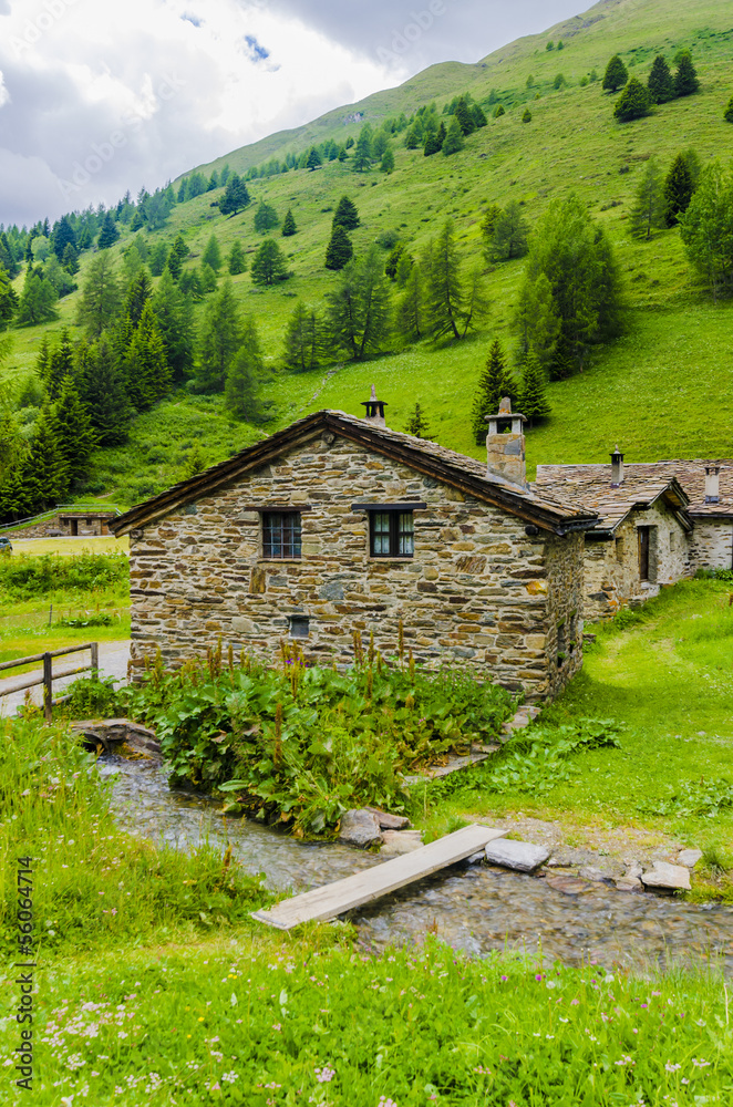Stone shepherd's house in a peasant village in alpine meadows Stone shepherd's house in a peasant village in alpine meadows
