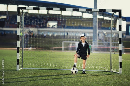 Little boy plays football on stadium © Aliaksei Lasevich