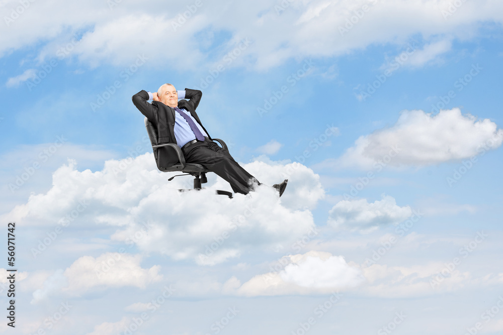 Mature businessman resting in armchair and floating on a cloud